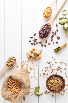Various dried legumes top view flat lay on white wooden background