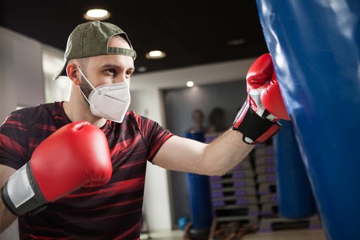 Young caucasian male wearing red boxing gloves & protective face