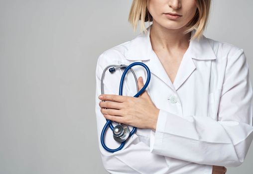 Professional doctor woman with blue stethoscope and white medical gown