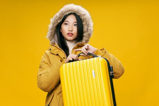 Woman in winter jacket yellow suitcase on vacation journey trip