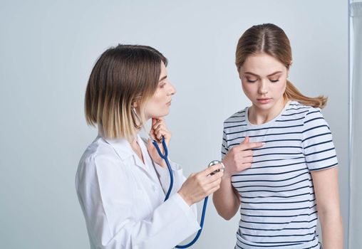 doctor woman in medical gown with stethoscope listens to patient's heart