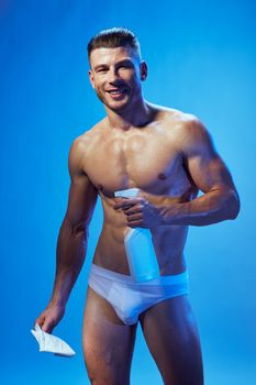 sporty man with muscular body in white panties detergent cleaning