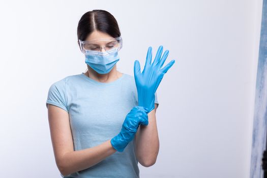 Nurse or doctor wearing and checking protective equipment agains