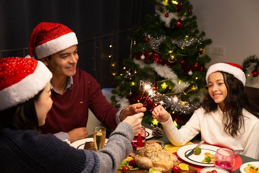 A family celebrate Christmas time together with dinner and spark
