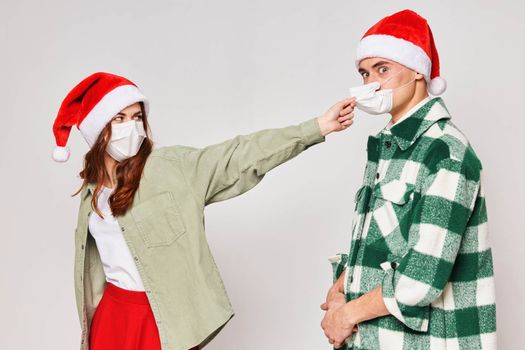 Man and woman in New Year's hats medical masks quarantine holiday New Year