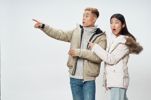 Young couple of Asian appearance in winter jackets dating surprise