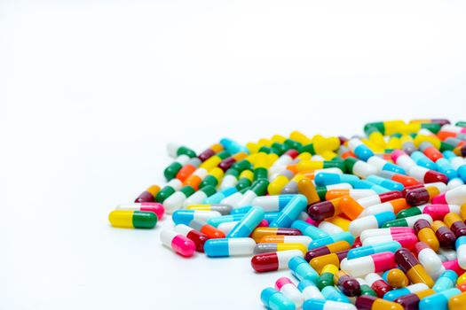 Heap of multi-colored antibiotic capsule pills on white backgrou