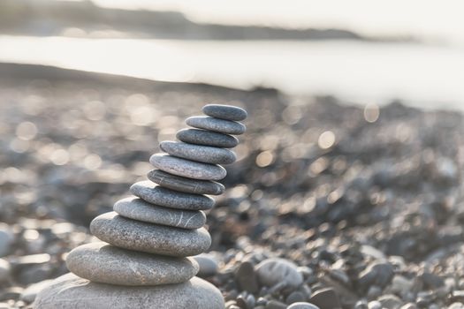 Pyramid of gray pebble stones on the beach of Turkey at sunrise. Zen concept, relaxation. calmness, balance