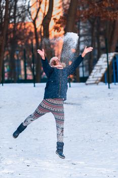 Happy teenage girl ready to throw a snowball