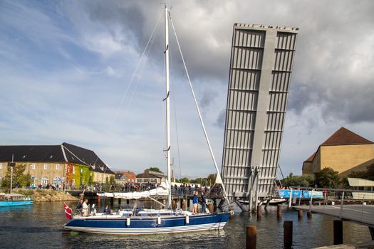 Sailboat passes open drawbridge in Copenhagen, Denmark