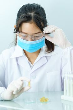 Scientist holding Omega 3 capsule in labcoat 