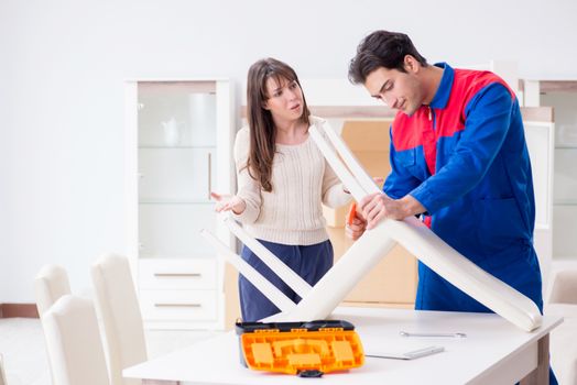 Contractor repairman assembling furniture under woman supervisio