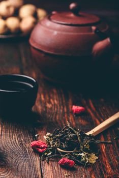 Tea bowls with teapot and spoonful of raspberry herbal tea