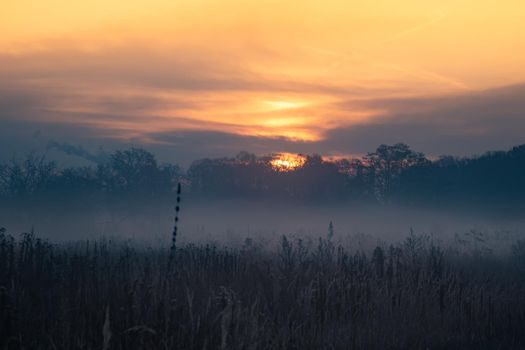 Majestic bright sunset cloudscape over a foggy field