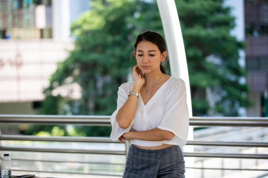 Portrait of young beautiful business woman at outside. Crossed arms
