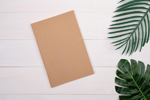 Blank cover book copy space with mockup and leaf on wooden table, poster and notebook, postcard decoration your design or branding, simplicity and minimal, nobody, flat lay, top view.