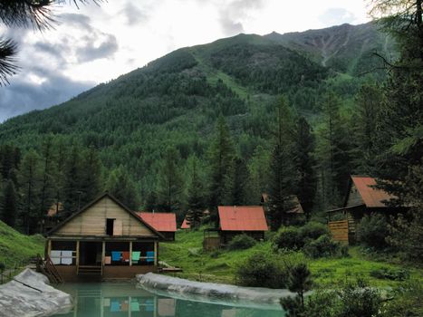 small tourist base with wooden houses in the forests of the Altai Mountains.