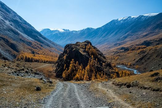A dirt road in mountains. The road to the rock. Altai.