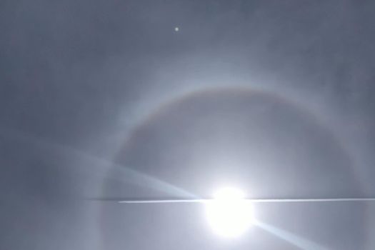 The plane flies through the halo. phenomenon of halo in the sky. A rare natural phenomenon. Three halo suns.