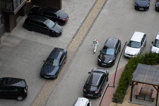 UKRAINE, KYIV - May 20, 2020: Man in a white protective suit and mask is walking on a street for sanitizing interior surfaces inside buildings while the coronavirus epidemic.