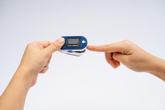 Fingertip Pulse Oximeter on finger. On white background. Device for self health diagnostic
