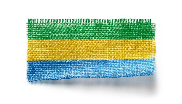 Gabon flag on a piece of cloth on a white background