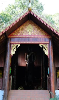 asian wooden buddhist temple with standing buddha statue stupa in Thailand