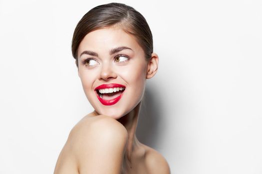 Young woman naked shoulders smile sideways glance open mouth red lips