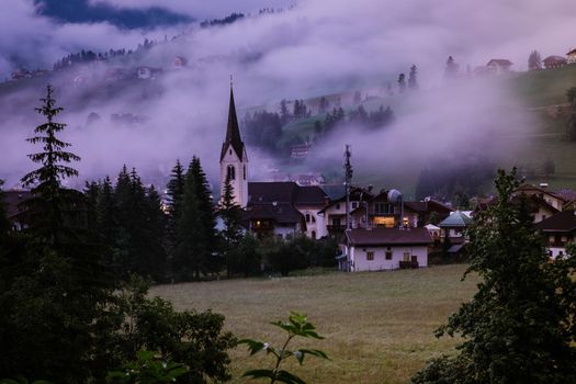 Dolomites Italy, small church during cloudy foggy weather, San Vigilio di Marebbe,South Tirol,Italy San Vigilio di Marebbe small town in Dolomites mountain