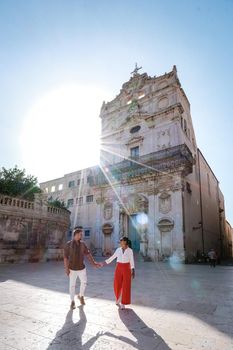 couple men and woman on citytrip Ortigia in Syracuse in the Morning. Travel Photography from Syracuse, Italy on the island of Sicily. Cathedral Plaza and market with people whear face protection during the 2020 pandemic