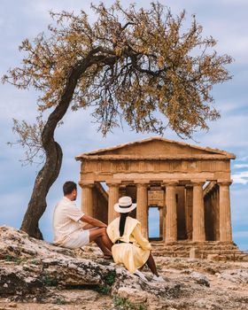 couple watching old temple during vacation at the Italian Island Sicily visiting the archelogical site of Agrigento valley of the temples