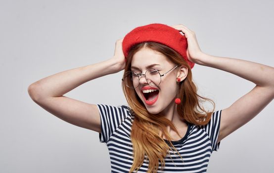 Happy woman in a red beret and in a striped T-shirt with makeup on her face