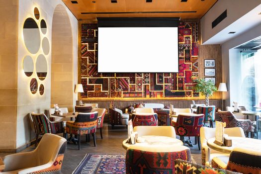 Cozy old style interior of restaurant, teahouse with white projector screen