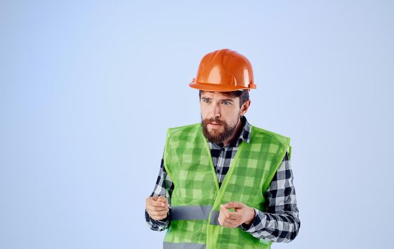 construction worker in orange hard hat on blue background and plaid shirt reflective vest