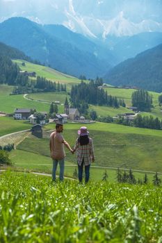 couple on vacation in the Dolomites Italy, Santa Magdalena Village in Dolomites area Italy Val di Funes