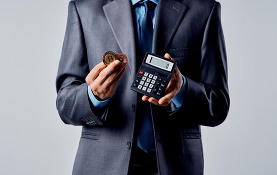 Businessman with calculator in hands and cryptocurrency Bitcoin wealth exchange rate