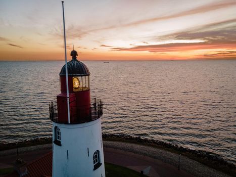 Urk lighthouse with old harbor during sunset, Urk is a small village by the lake Ijsselmeer in the Netherlands Flevoland area