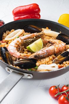Paella with seafood and chicken on white background
