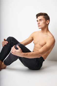 Handsome male naked torso sitting on the floor attractive look model