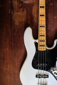 white electric bass guitar on wood background