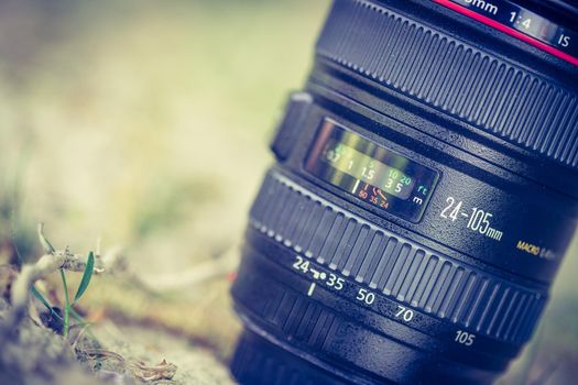 Professional optic photo lens outdoors. Warm colors, blurry background.
