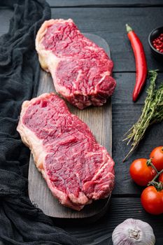 Top sirloin beef steak cut, on black wooden table