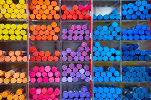 Multicolored pastel crayons art store in wooden cells