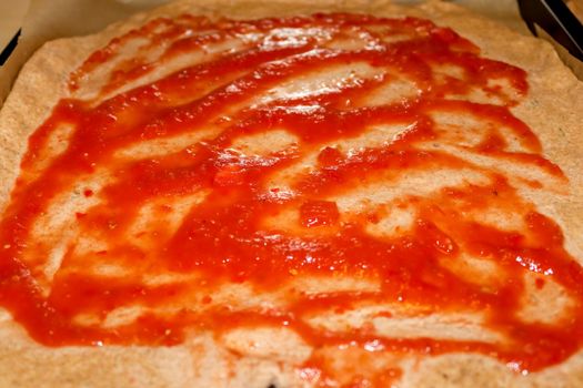 Homemage pizza dough with tomatoe sauce and no topping.