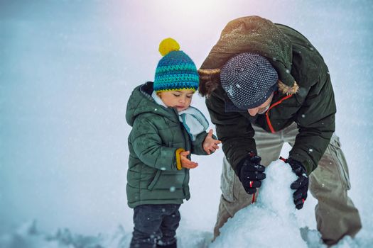 Happy Father with Son Making Snowman