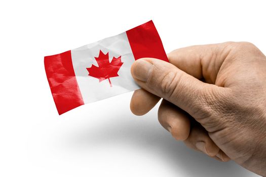 Hand holding a card with a national flag the Canada