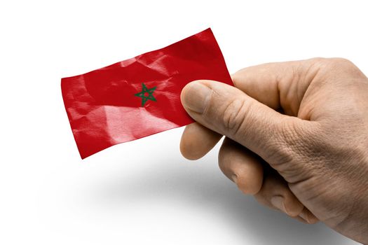 Hand holding a card with a national flag the Morocco