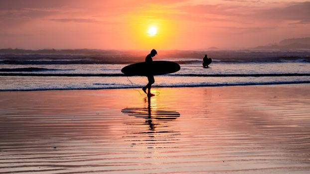Tofino Vancouver Island Pacific rim coast, surfers with board during sunset at the beach, surfers silhouette Canada Vancouver Island Tofino. 