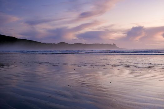 sunset on the beach of Tofino Vancouver island, pink purple soft colors in the sky during sunset