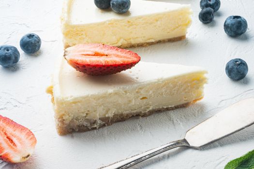 Portion of cheesecake with berries, on white background